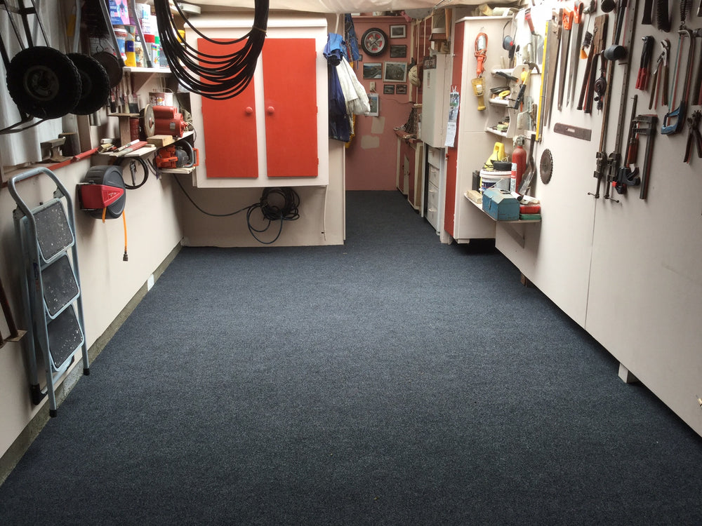 Garage with lots of tools on the wall with charcoal garage carpet laid