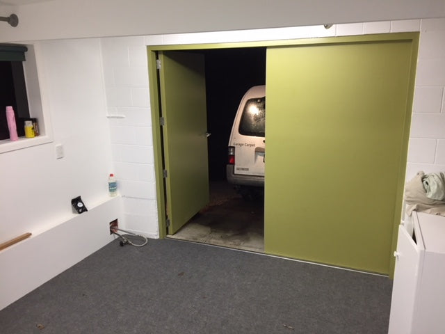 Garage carpet with a green garage door with van in background