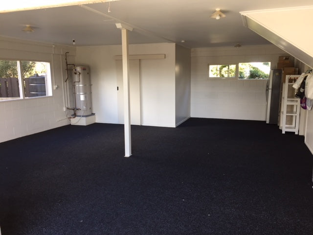 garage with a pole in the centre with newly installed charcoal garage carpet